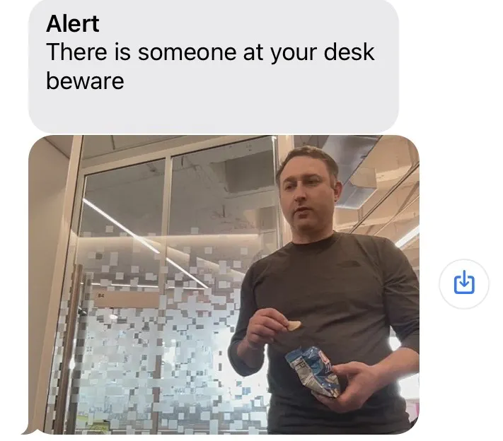 Text message reading “Alert There is someone at your desk beware” with a photo of a person (Steve) detected by the camera as he approaches the desk.