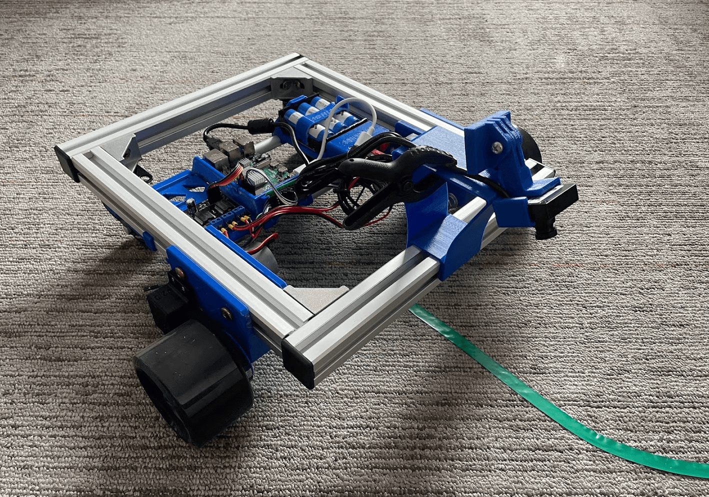 A Scuttle robot base with a camera mounted on the front, pointing mostly down and slightly forwards.